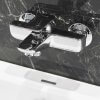 srebrna armatura wannowa w łazience z czarnym marmurem